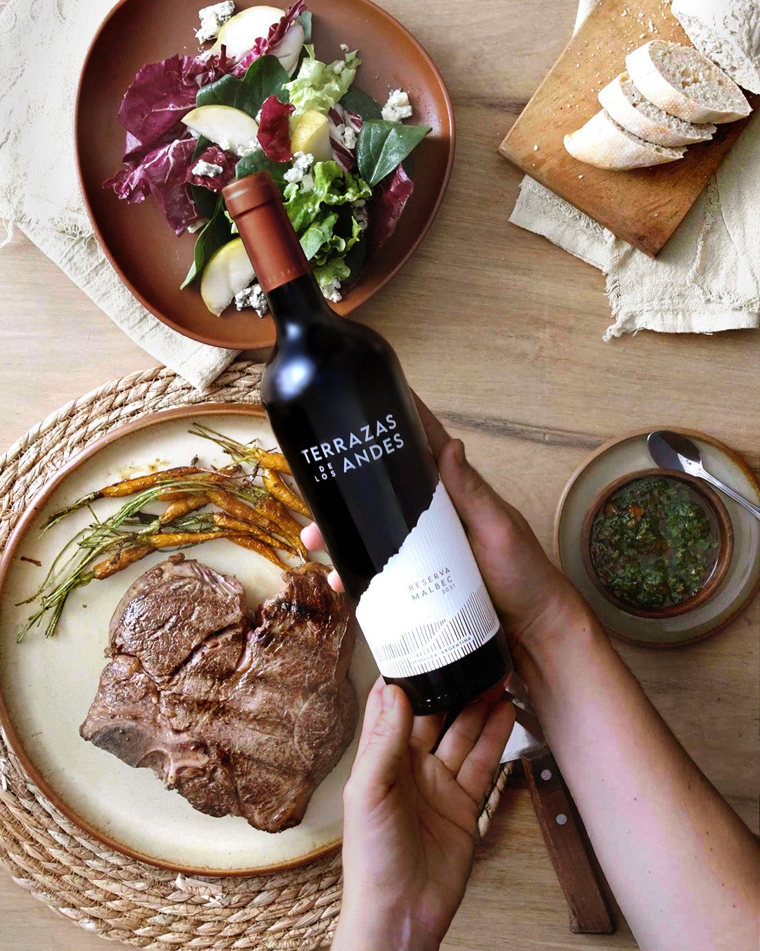 Rode fles wijn aan tafel met vleesgerecht